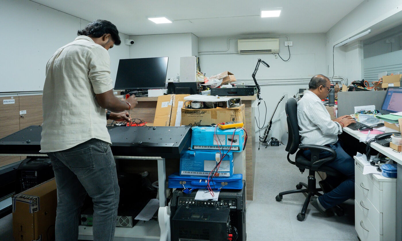 Technicians repairing a keyboard and diagnosing equipment at the NES service center